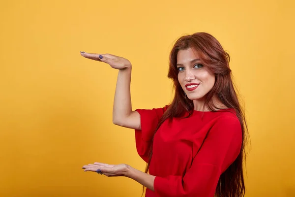 Magnifique femme européenne démontrant un bon produit par les deux mains . — Photo