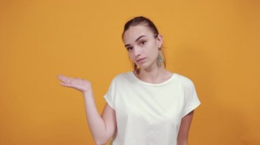 Düzgün bir kız bir şey göstermek için elini sallıyor..