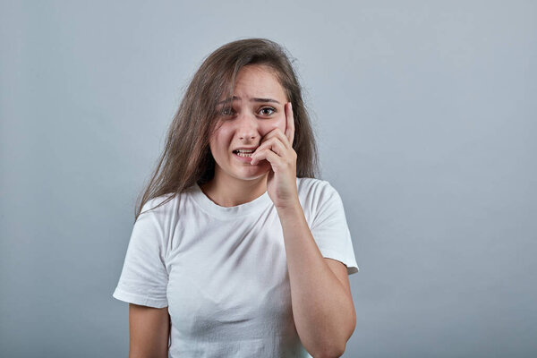 Woman with long hair over isolated grey wall nervous and scared