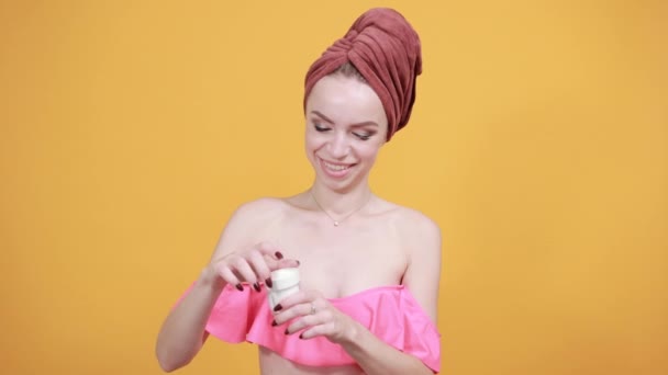 Young girl with towel on her head over isolated orange background shows emotions — Stock Video