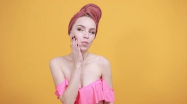 izole turuncu arka plan üzerinde kafasına havlu ile genç kız duygularını gösterir