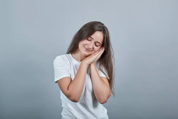 Jovem caucasiana com t-shirt fazendo gesto de sono em expressão dormente . — Fotografia de Stock