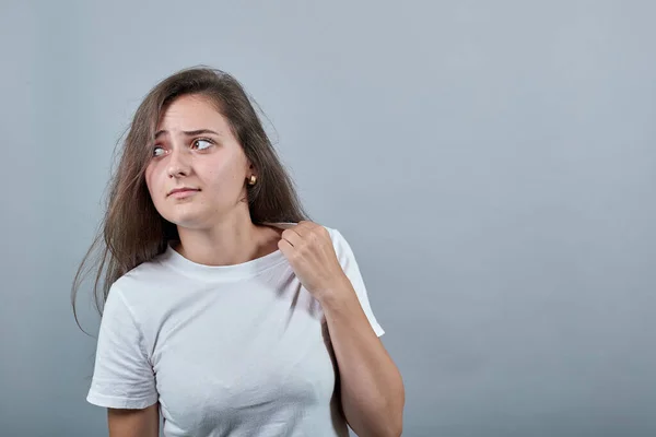 Mujer de pelo largo sobre pared gris aislada con expresión cansada y enferma — Foto de Stock