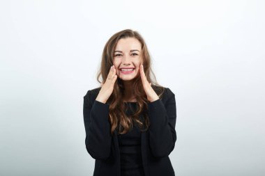 Elleriyle yanaklarına dokunuyor ve gülümsüyor, pürüzsüz, pürüzsüz bir ten, çekici.