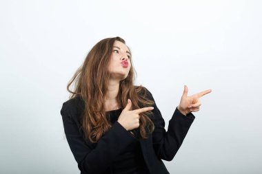 İşaret parmağıyla işaret eden, genç çekici esmer kadın.