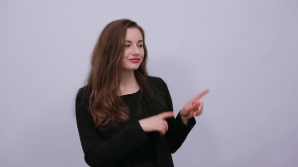 Zeigt mit dem Zeigefinger zur Seite, junge attraktive Frau brünett — Stockvideo