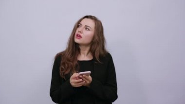 Elinde telefon tutan odaklanmış bir kadın var. İletişim Smartphone aracılığıyla