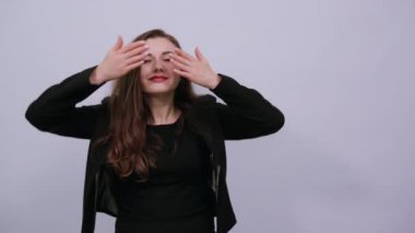 Avuç içleri kapalı olduğu için gözleri elleriyle görülebiliyor. Çekici bir kadın.