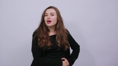 Şirin bir kadın avuç içini alnına yakın tutuyor ve mesafeye bakıyor. Beklenti