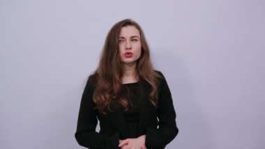 Odaklanmış dişi kıyafetleri elleriyle tutar, düşünür. Zeki insanlar, entelektüeller.