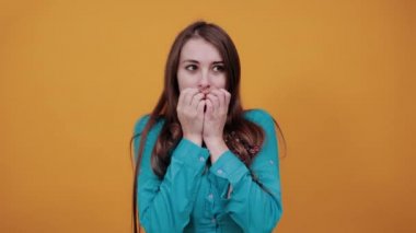 Korkmuş, duygusal olarak yumruklarını ısırıyor. Parmak ekleminin arkasını kapatıyor. Korkmak..