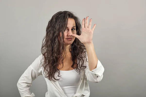 Pulling face, holding thumb nose, teasing is putting fingers to head, gesture Stock Picture