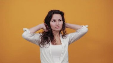 Gülümseyen genç model saçlarını tarıyor, moda pozları veriyor, elleri iplik gibi.