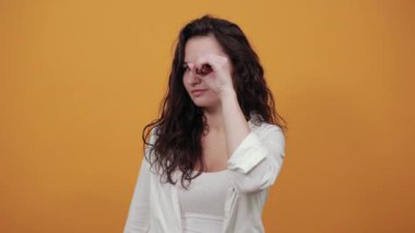 Gözlük takıyor, kameraya bakıyor, gülümsüyor, komik, el ele tutuşuyor.