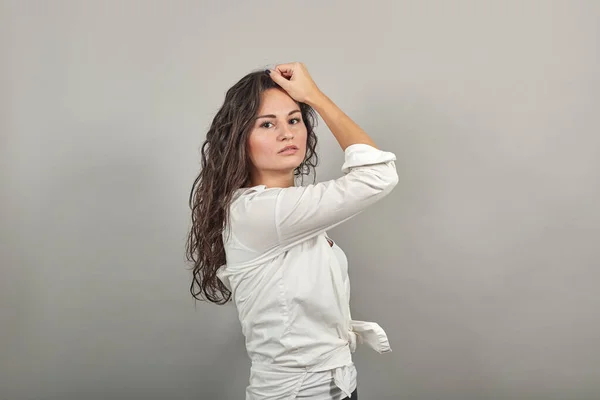 Adolescente modelo sonriente cepillando la mano a través del cabello, posando de moda, manos en hebra —  Fotos de Stock