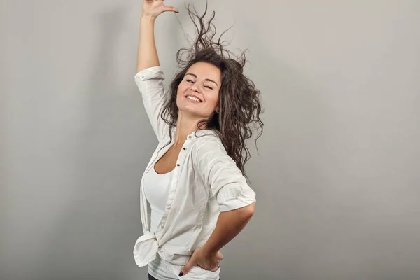 Adolescente modelo sonriente cepillando la mano a través del cabello, posando de moda, manos en hebra —  Fotos de Stock