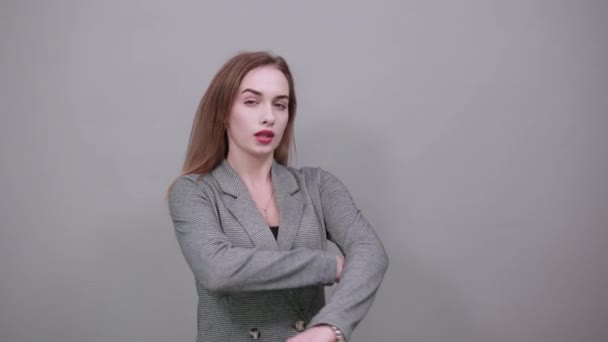 Stå och korsa armarna på bröstet. Ung attraktiv kvinna, klädd grå jacka — Stockvideo