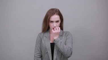 Korkmuş, duygusal olarak yumruklarını ısırıyor. Parmak ekleminin arkasını kapatıyor. Korkudan. Gergin.