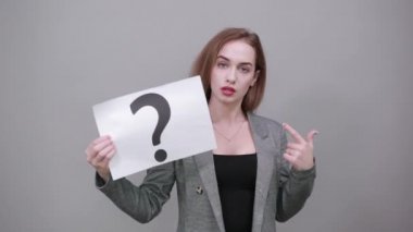 Beyaz bir kağıt parçasındaki siyah soru işareti. Yakın plan el ele tutuşma sembolü