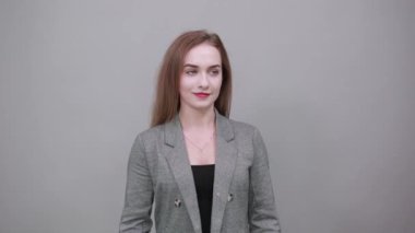 Kollar havaya, sevinçle başarı yumruklarını kutlayalım. Genç çekici kadın, gri.