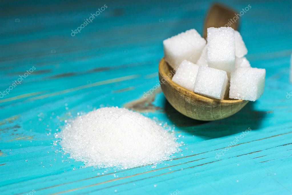 White sugar refined and crystallized on a blue background