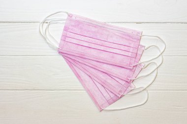 Beyaz arka planda pembe renk koruyucu tıbbi maske.