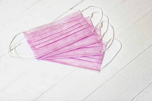 Beyaz arka planda pembe renk koruyucu tıbbi maske.