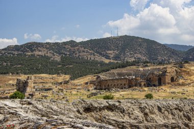 Arkasında dağlar olan kayalık arazi manzarası.