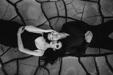 Asyalı aşık bir çift yerde yatarken sarılır. Arka plan