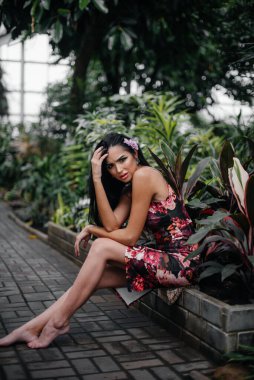 Genç ve güzel bir esmer, sık orman ve yağmur ormanları arasında poz veriyor. Spa