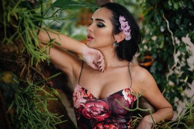 Genç ve güzel bir esmer, sık orman ve yağmur ormanları arasında poz veriyor. Spa