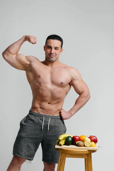 性感的纯素食主义者赤身裸体躺在水果旁边的工作室里节食 健康饮食 — 图库照片