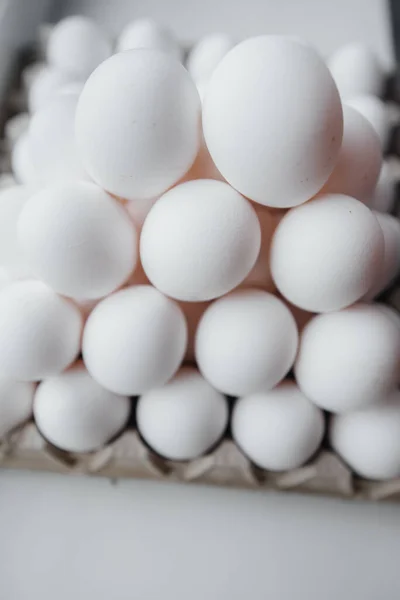 段ボールの上にピラミッドによって描かれたクローズアップで白い新鮮な卵のトレイ — ストック写真