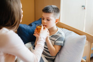 Anne hastalık ve virüs sırasında bebeğine limonlu sıcak çay verir. İlaç ve bakım