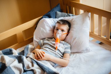 Genç bir çocuğa akciğer hastalığı sırasında solunum yoluyla solunum yapılır. İlaç ve bakım