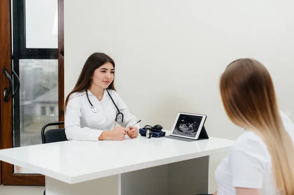 赤ん坊が超音波の後の婦人科医に相談するのを待っている若いカップル 妊娠中や健康管理 — ストック写真