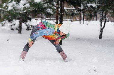 Genç bir atletik kız soğuk bir günde koşmadan önce ısınıyor. Fitness, çalışma