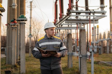 Enerji mühendisi istasyonun ekipmanlarını inceler. Güç mühendisliği. Sanayi