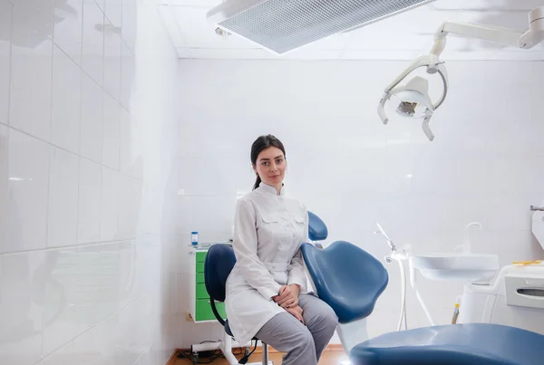 A professional dentist stands in a modern light dental office. Dentistry