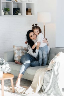 Anne ve kızları kanepede oynuyorlar. Bir aile. Mutluluk.