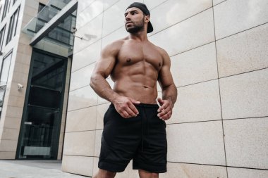 Sıcak güneşte üstsüz poz veren seksi adam. Fitness. Yaşam biçimi
