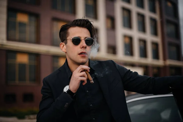 スタイリッシュなビジネスマンは高級車の近くで葉巻を吸う ファッション ビジネス — ストック写真