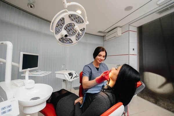 A young doctor treats his patient\'s teeth. Dentistry