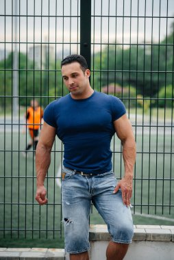 Sporcu çocuk spor sahasının yanında duruyor. Vücut geliştirme