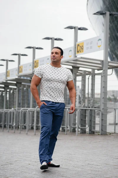 A sports guy stands and enjoys a walk near the stadium. Lifestyle