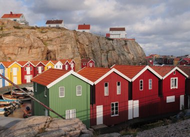 Smogenbryggan 'da güneşli bir yaz gününde gökyüzünde bulutlu renkli kayıkhaneler