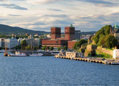Oslofjord 'dan Red Brickstone Belediye Sarayı' na güneşli bir yaz gününde açık mavi gökyüzü ve birkaç bulutla birlikte