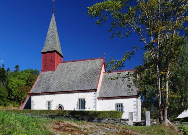 Güneşli bir yaz gününde açık mavi bulutsuz gökyüzü ile Dalsfjord 'daki Küçük Taş Şapel Dale Kirke