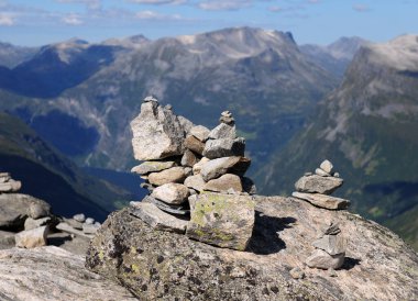 Dalsnibba 'daki Kaya Yığını. Güneşli bir yaz gününde arka planda Geirangerfjord' un geniş dağları açık mavi gökyüzü ve birkaç bulutla birlikte.