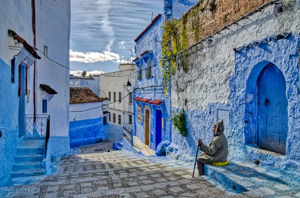 一个头戴头巾的人坐在五颜六色的历史村庄台阶上 Chefchaouen 摩洛哥 — 图库照片
